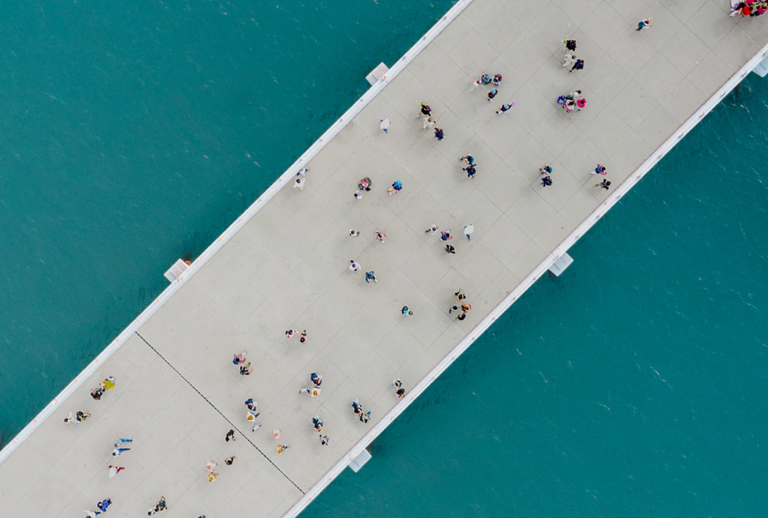 Image of people walking over a bridge over a river