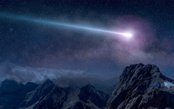 A purple shooting star at night over the mountain range